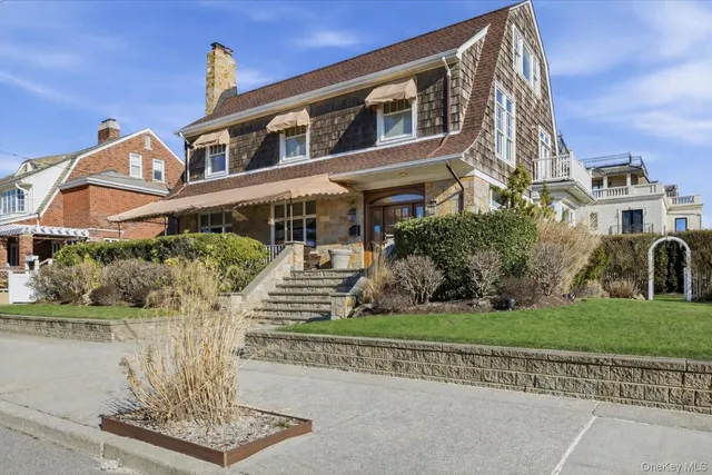 a front view of a house with a garden and plants