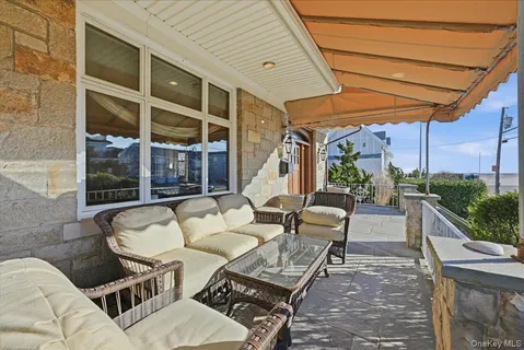 a view of an outdoor sitting area with furniture and floor to ceiling window