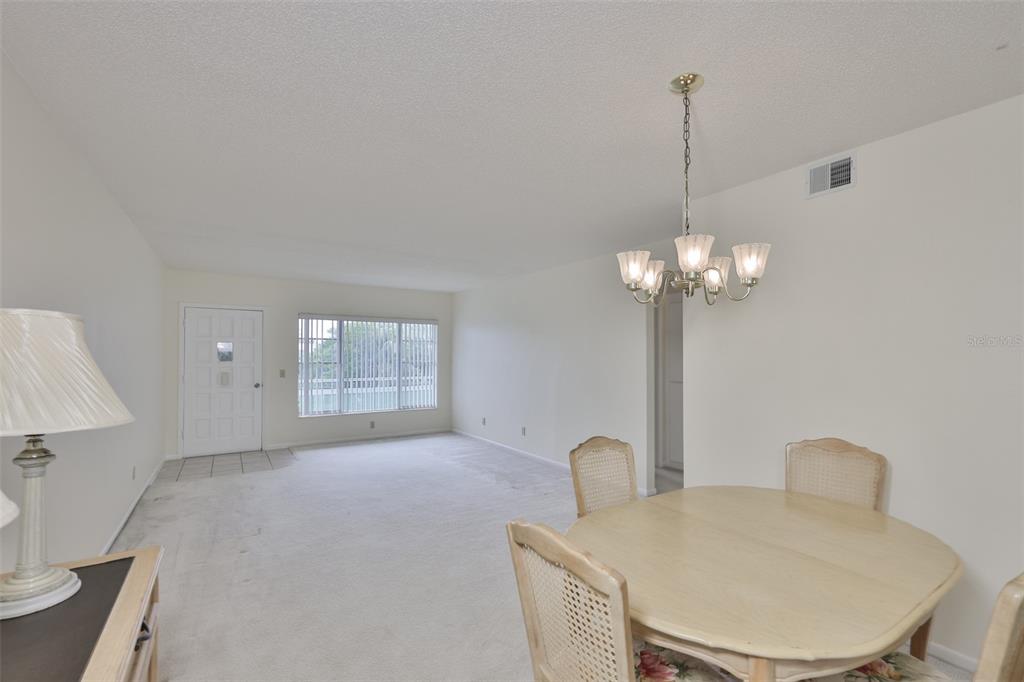 2358 Ecuadorian Way, Unit 56 Clearwater, FL 33763 - Photo 11 of 33 a view of a livingroom and a kitchen with a chandelier