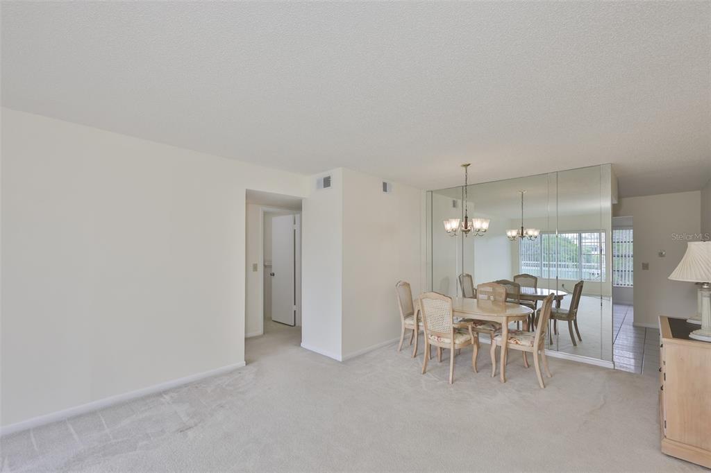 2358 Ecuadorian Way, Unit 56 Clearwater, FL 33763 - Photo 12 of 33 a dining room with furniture and a chandelier