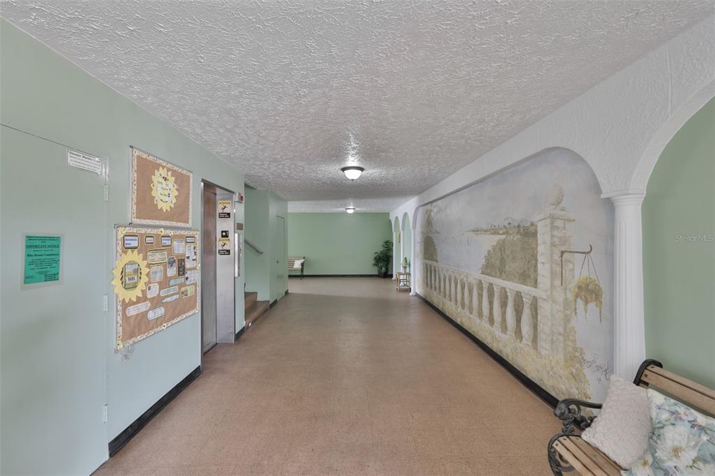 2358 Ecuadorian Way, Unit 56 Clearwater, FL 33763 - Photo 33 of 33 a view of a hallway with paintings on the wall