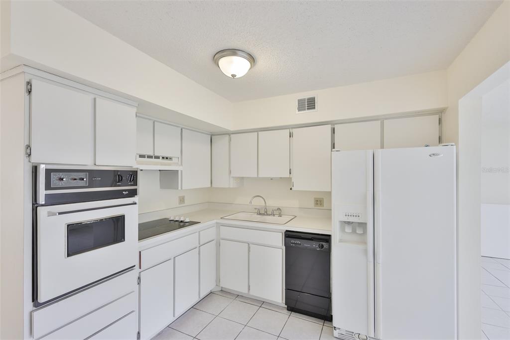 2358 Ecuadorian Way, Unit 56 Clearwater, FL 33763 - Photo 5 of 33 a kitchen with a white cabinets and white appliances