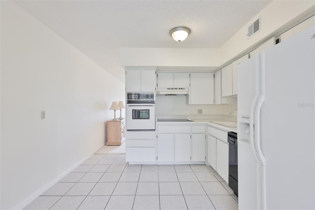 2358 Ecuadorian Way, Unit 56 Clearwater, FL 33763 - Photo 6 of 33 a kitchen with white cabinets and white appliances