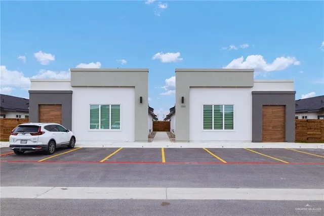 a front view of a house with a parking space