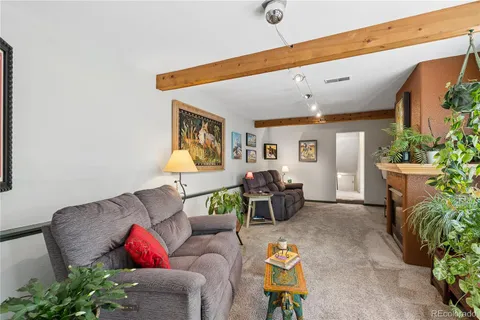 a living room with furniture and a potted plant