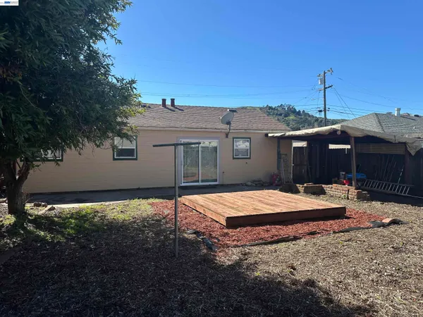 a backyard of a house with barbeque oven table and chairs