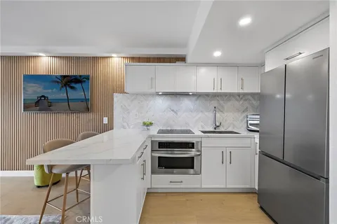 a kitchen with stainless steel appliances granite countertop a refrigerator sink and stove