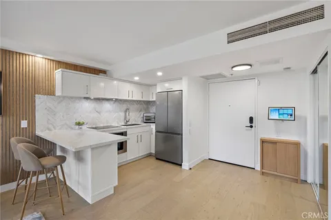 a living room with furniture and a dining table with kitchen view