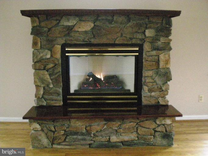 6307 Chesworth Road Catonsville, MD 21228 - Photo 12 of 18 Gas fireplace with mantle and stone front