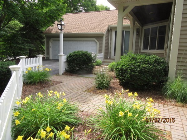 153 Nobscot Road, Unit 153 Sudbury, MA 01776 - Photo 2 of 18 a view of a house with potted plants and a fountain