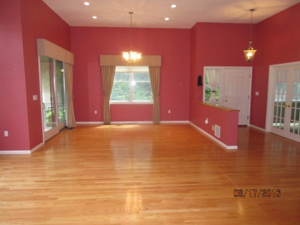 153 Nobscot Road, Unit 153 Sudbury, MA 01776 - Photo 4 of 18 a view of an empty room with window and a kitchen