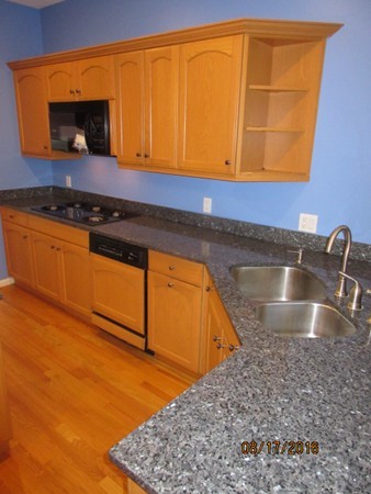 153 Nobscot Road, Unit 153 Sudbury, MA 01776 - Photo 7 of 18 a kitchen with granite countertop sink and cabinets