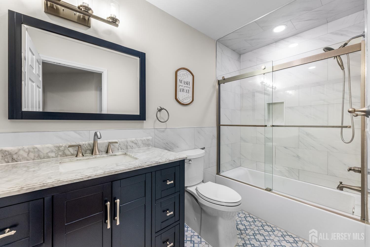 7 Edith Drive Somerset, NJ 08873 - Photo 23 of 49 a bathroom with a granite countertop sink a toilet mirror and shower