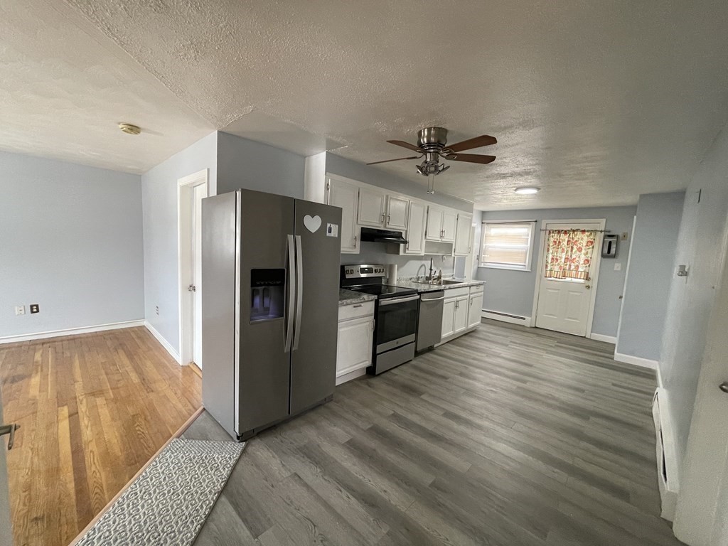 72 Longfellow Road Worcester, MA 01602 - Photo 4 of 36 a kitchen with stainless steel appliances a refrigerator a sink dishwasher a stove and white countertops with wooden floor