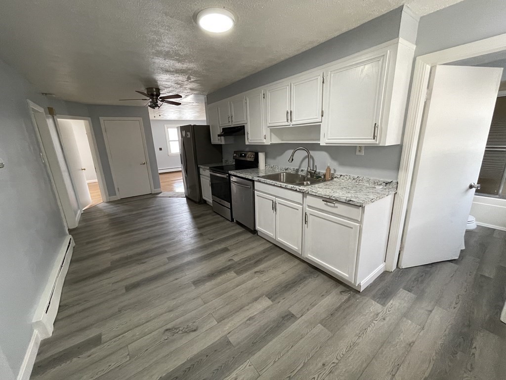 72 Longfellow Road Worcester, MA 01602 - Photo 5 of 36 a kitchen with granite countertop white cabinets and white appliances