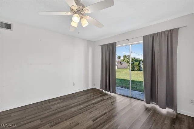 a view of an empty room with glass door and a window