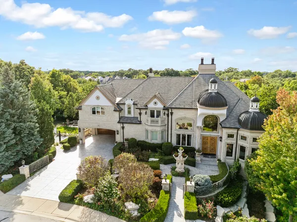 a view of a house with a big yard and large trees