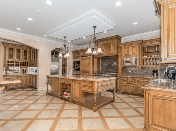 a large kitchen with stainless steel appliances granite countertop a sink a counter space cabinets and a window