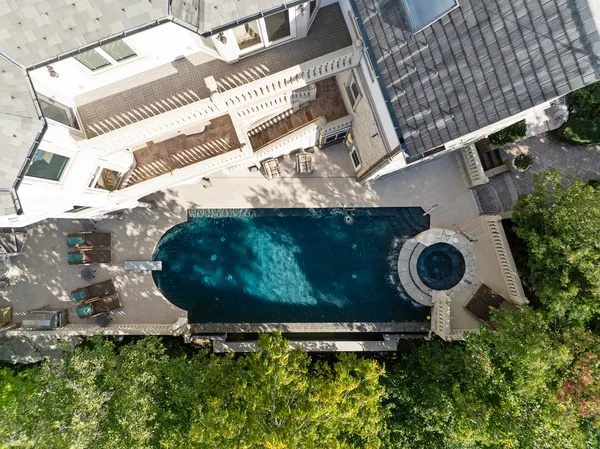 an aerial view of a backyard with chairs and a fire pit