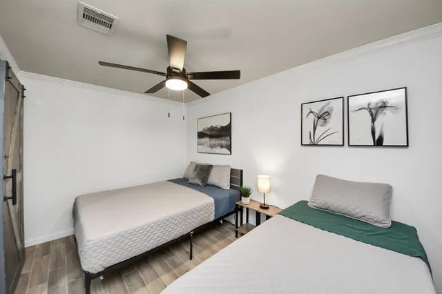 a spacious bedroom with a bed and a flat screen tv