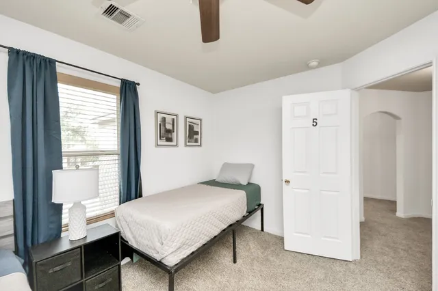 a bedroom with a bed and a wall painting