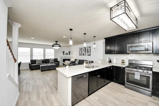 a kitchen with a sink a counter top space stainless steel appliances and cabinets