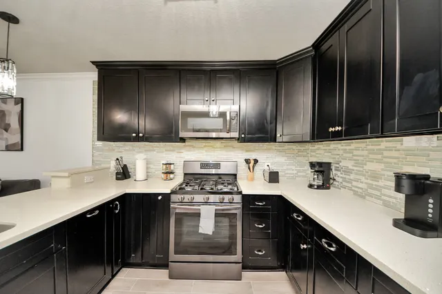 a kitchen with stainless steel appliances a sink stove and cabinets