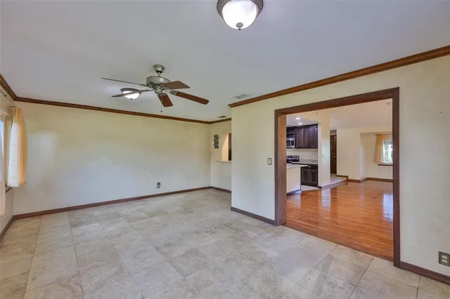 a view of a livingroom with wooden floor and a ceiling fan