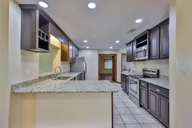 a kitchen with stainless steel appliances granite countertop a stove a sink and a microwave