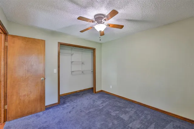 an empty room with closet and fan