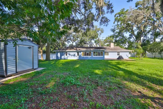 a view of a house with backyard and a tree