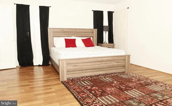 a large bed sitting in a bedroom next to a window