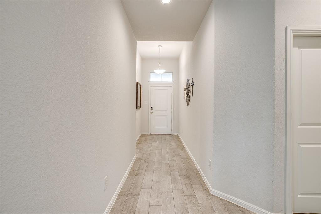 2313 Stallings Road Fort Worth, TX 76108 - Photo 3 of 30 a view of a hallway with wooden floor and a bathroom