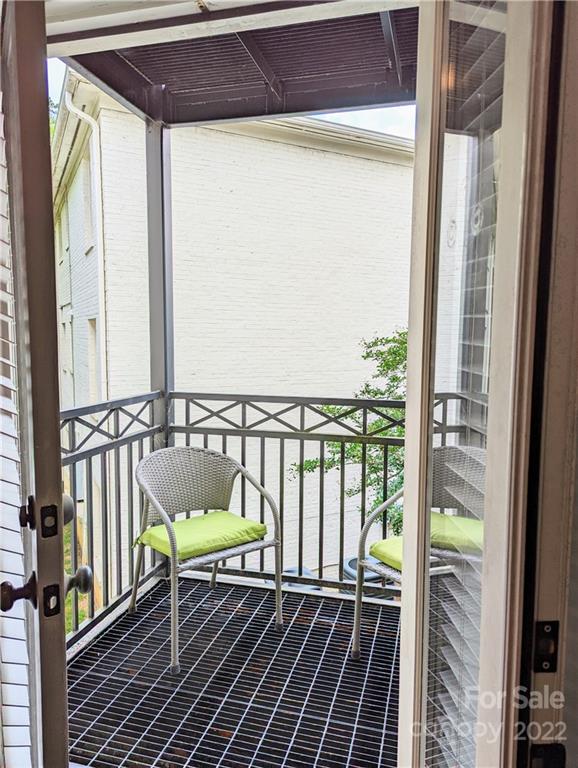 4915 Park Road, Unit C Charlotte, NC 28209 - Photo 11 of 22 a balcony with wooden floor table and chairs