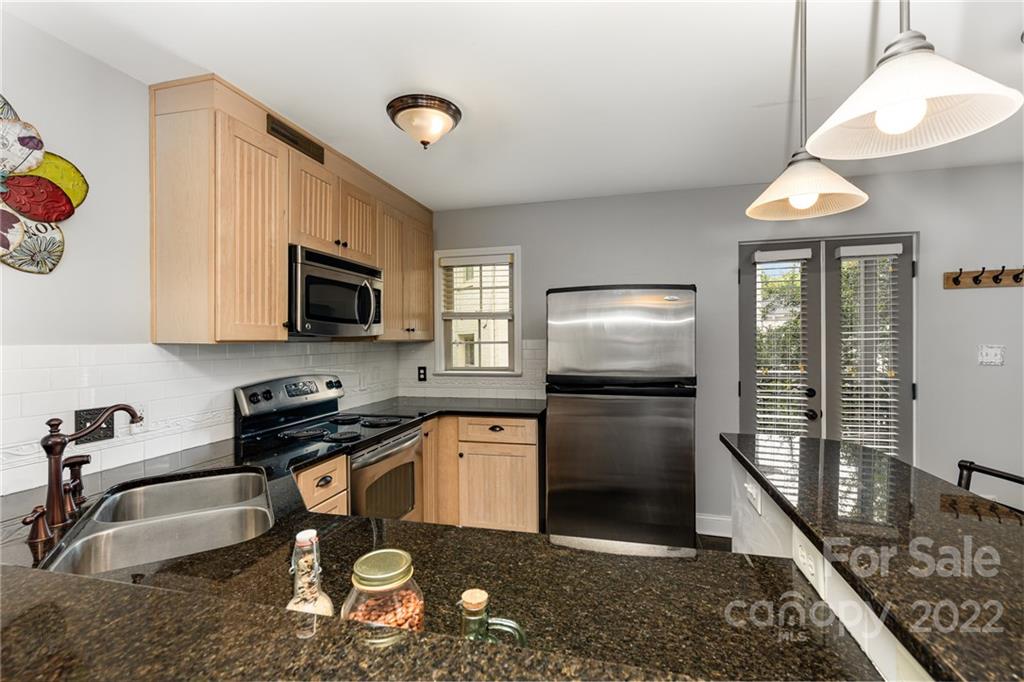 4915 Park Road, Unit C Charlotte, NC 28209 - Photo 5 of 22 a kitchen with stainless steel appliances granite countertop a sink a stove cabinets and a refrigerator