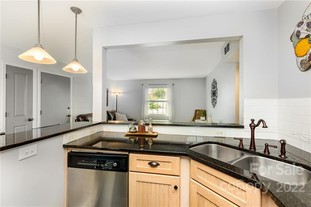 4915 Park Road, Unit C Charlotte, NC 28209 - Photo 6 of 22 a kitchen with granite countertop a sink a counter space and cabinets