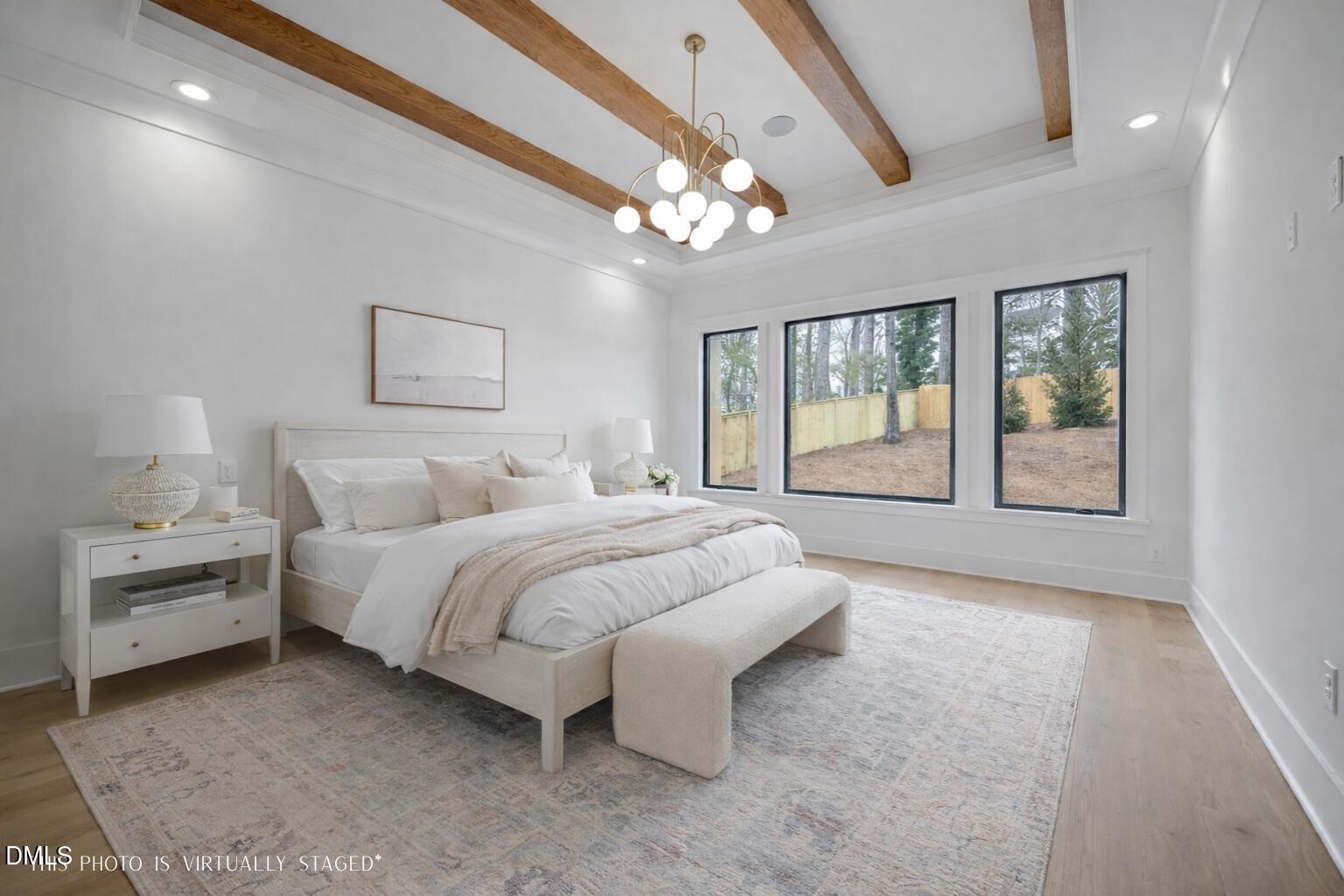 1312 Hunting Ridge Road Raleigh, NC 27615 - Photo 17 of 52 a spacious bedroom with a large bed and a chandelier fan