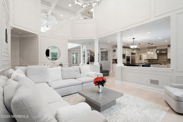 a living room with furniture a dining table and white walls