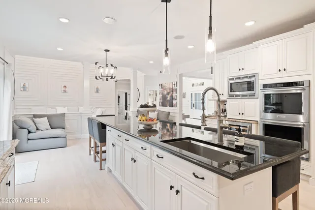 a large kitchen with kitchen island a dining table and chairs