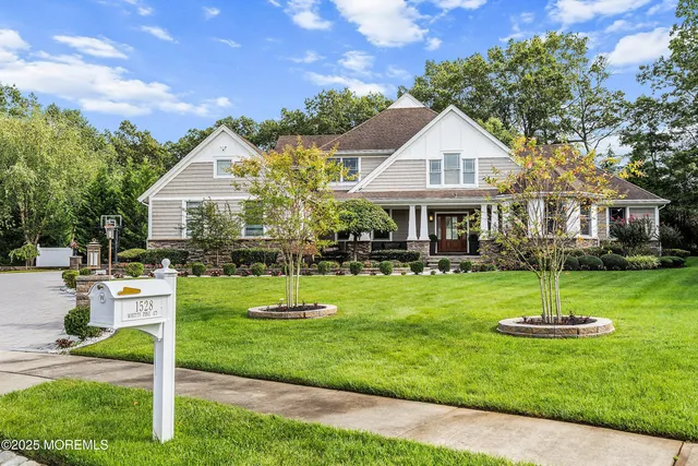 a view of a house with backyard and a trees
