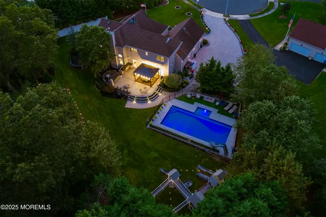 a front view of a house with a garden and trees