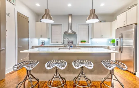 a kitchen with kitchen island a sink a counter top space stainless steel appliances and a window
