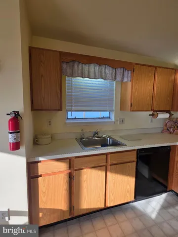 a kitchen with granite countertop white cabinets sink and window