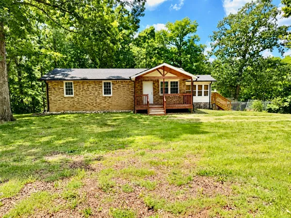 a big yard with table and trees in the background