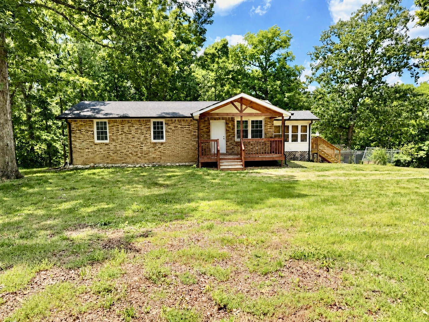 a big yard with table and trees in the background
