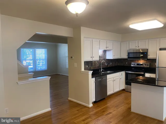 a kitchen with stainless steel appliances granite countertop a stove and cabinets