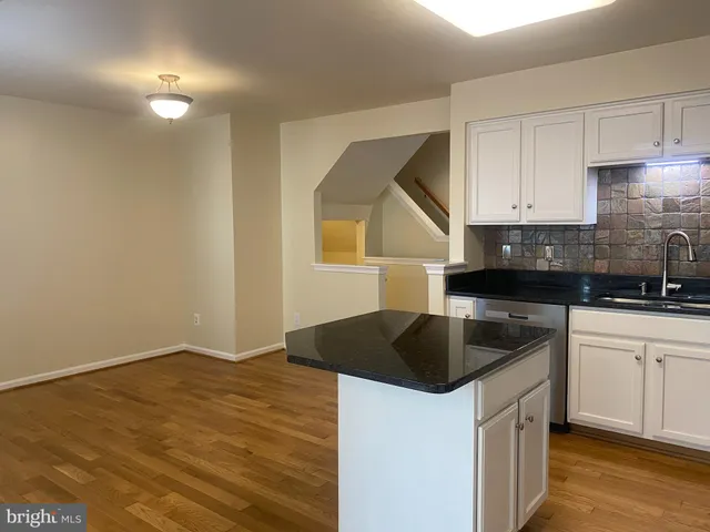 a kitchen with granite countertop a refrigerator a stove a microwave and cabinets