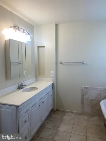 an empty room with wooden floor closet and windows