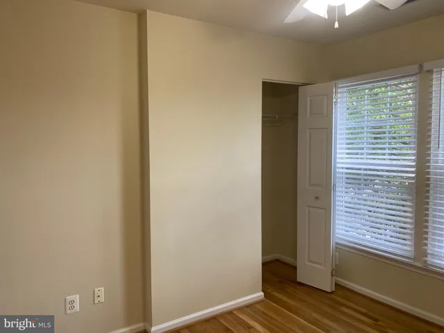 a view of a small space with wooden floor and a fan