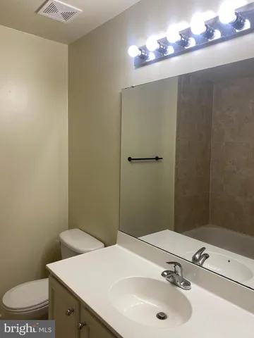 a bathroom with a sink a mirror and toilet